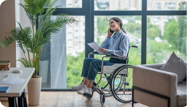 Person in a wheelchair using a smartphone in a modern office setting