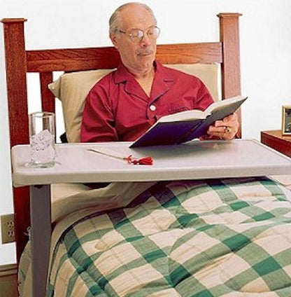 hospital bed with a man in it with a bedside table and a beverage