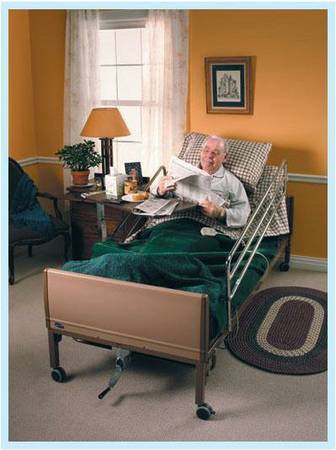 hospital bed with a man in the bed reading a news papaer